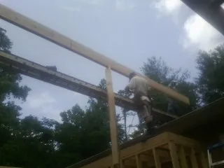 Carpenter setting a ridge beam over a new addition frame — Ice Dam Removal by Roofing Brothers in Schooleys Mountain