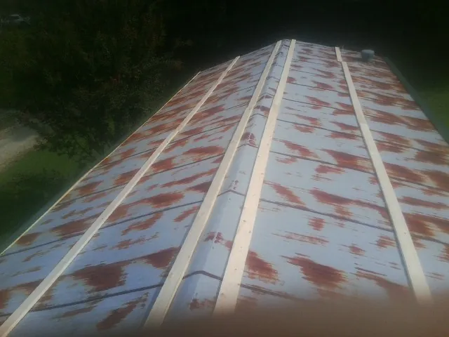 Rusted metal roof panels with new wood purlins before replacement — Storm Damage Roof Repair in Schooleys Mountain by Roofing Brothers