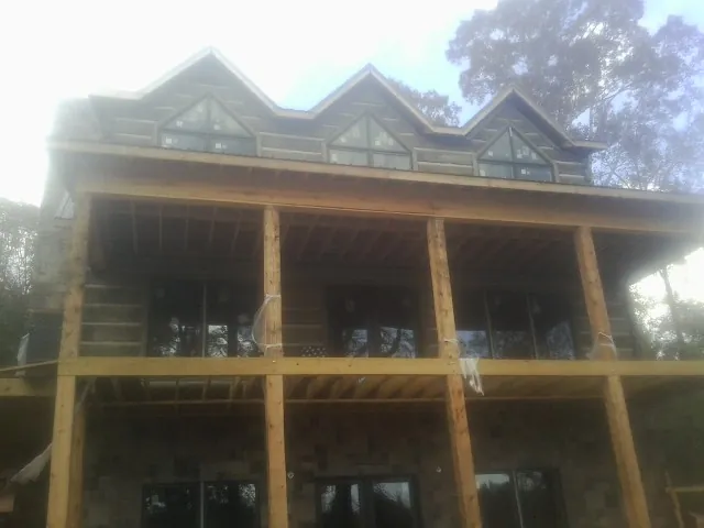Dormers and porch framing on a large log home under construction — Roof Coating work by our crew in Schooleys Mountain